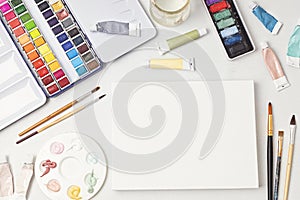 Artist painting color palettes, brushes and white canvas. Craft hobby background