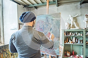 An artist painting a masterpiece at his studio photo