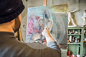 An artist painting a masterpiece at his studio - close up shot