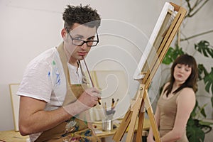 Artist painting model at art studio