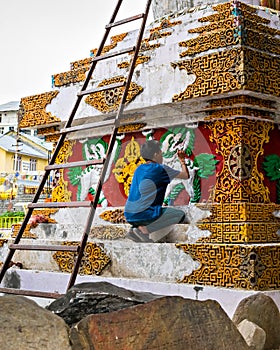 Artist painting pagoda in Manali, Himachal Pradesh, India.