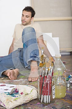 Artist With Painting Tools Sitting On Studio Floor