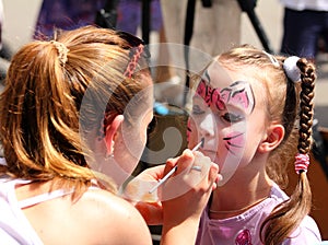 Artist paints on face of little girl