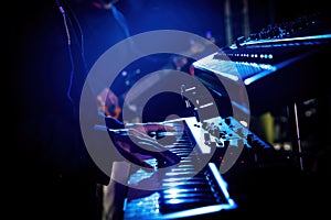 Artist playing on the keyboard synthesizer piano keys during the live concert.