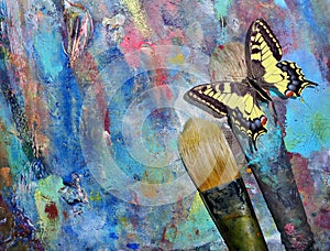 ArtistÃ¢â¬â¢s brushes and palette. colorful butterfly sitting on a brush. color concept in art. photo