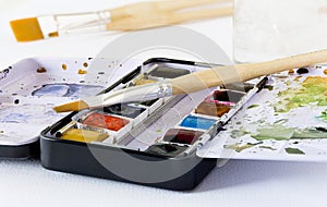 An artist`s metal compact travel paint tin