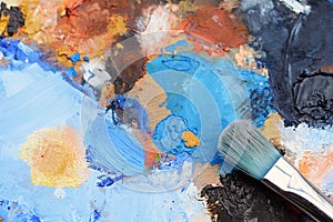 Artist`s palette with colorful oil paint strokes and paintbrushe