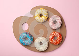 Artist`s palette made with donuts and cardboard on pink background, top view