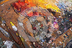 Artist`s Palette and Palette Knives Covered in Paint