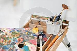 Artist`s tools on the easel. Brushes, paints and canvas.