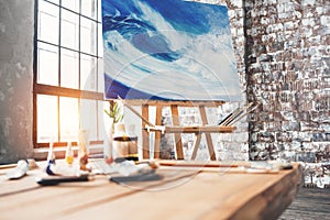 Artist`s workplace in the studio. Painting on canvas on the easel in the studio. Artist workshop