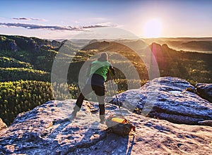 Artist set camera and tripod to photograph sunrise on summit photo