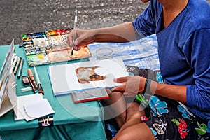 Artist street painter sketching a Dog portrait on night Market street in KhonKaen Thailand at 29 May 2016