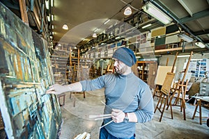 Artist/teacher painting and artwork in his art studio