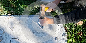 Artist using chisel and mallet to carve in stone photo