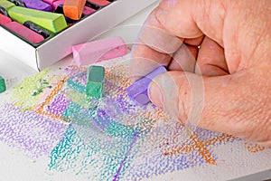 An artist using soft chalk pastel crayons