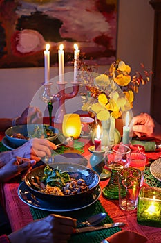 Artistic autumn tablescape: porcelain, candlelight, and diners\' hands