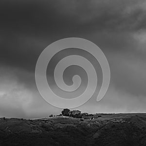 Artistic black and white image of simple house on a hill in Tuscany, Italy