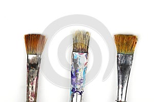 Artistic brushes close up. Watercolor paints in the background. Background with brushes and paints