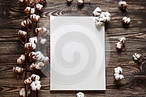Artistic canvas and cotton plant. white blank cotton canvas on brown wooden background. Top view. Mockup