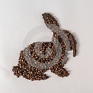 Creative rabbit silhouette formed by aromatic dark coffee beans.