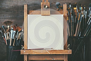 Artistic equipment in a artist studio: empty artist canvas and brushes. photo