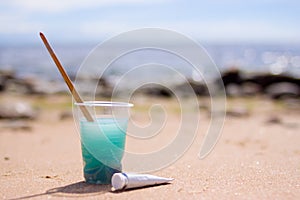 Artistic equipment: paint brushes, tubes of paint, palette and paintings on rock in nature sea shore at sunny summer day - creatio