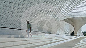 Artistic performer jumping stairs wide shot. Young man contemporary dance alone