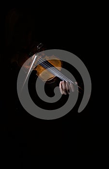 Artistic photo of violinist playing the violin , isolated in dark background, only violin.Close-up of musician playing violin.