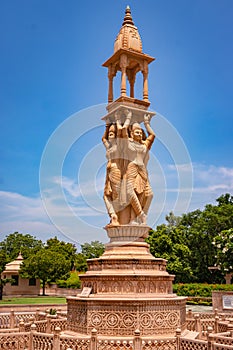 artistic red stone jain god holy pillar at morning from unique angle