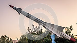 an artistic sculpture in the shape of a rocket or missile with a red fin