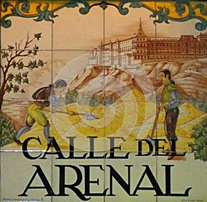 Artistic street sign in central Madrid showing historical building and aristocratic workers in foreground