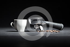 Artistic studio shot of holder for coffee machine, white cup and