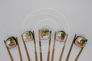 Artistic Sushi Presentation with Chopsticks on White Background