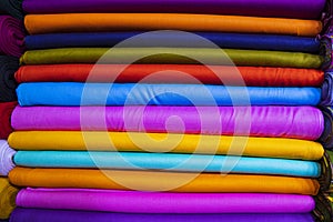 Artistic variety of shade tone colors Textile Fabrics stacked on retail Shop Shelves