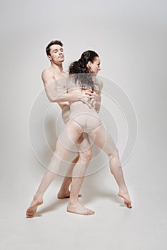 Artistic young dancers performing in front of the white background