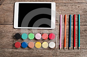 An artists design tablet and paint palette and pencils