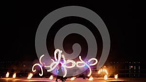 Artists juggling with burning poi's at fire performance.