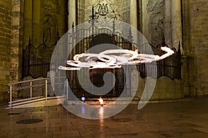 Artists juggling with two burning poi`s at fire performance. Long exposure causing painting with light