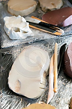 Artists Moulding clay of various colours with sculptors tools