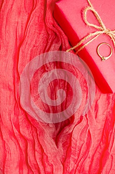 Artvagina. Textile abstract background. Soft folds of pink fabric in the shape of a vagina, gift box and a ring on it photo