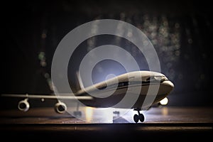 Artwork decoration. White passenger plane ready to taking off from airport runway. Silhouette of Aircraft during night time