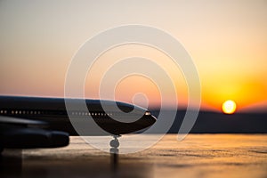 Artwork decoration. White passenger plane ready to taking off from airport runway. Silhouette of Aircraft during sunset time