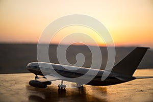 Artwork decoration. White passenger plane ready to taking off from airport runway. Silhouette of Aircraft during sunset time