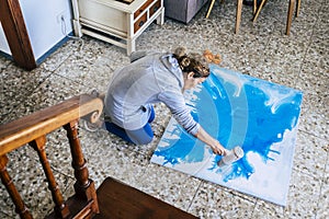 Artwork at home and people doing art painted on the floor in the house - caucasian woman  and blue wall paper - artistic activity