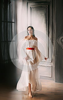 Woman dark hair bare shoulders long white vintage medieval luxurious dress.