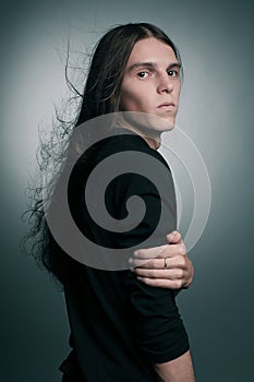 Arty portrait of a fashionable male model with long hair