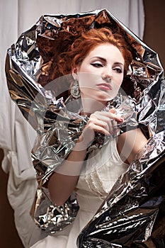Arty portrait of a fashionable queen-like model with silver foil