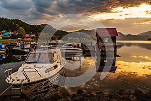 Pleasure boats at the lake wharf with a wooden pier at dawn