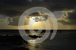 Aruba sunset with storm clouds, golden light, and ocean